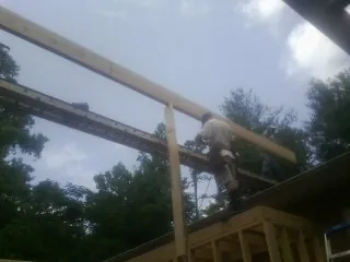 Carpenter setting a ridge beam over a new addition frame — Ice Dam Removal by Roofing Brothers in Redwood City