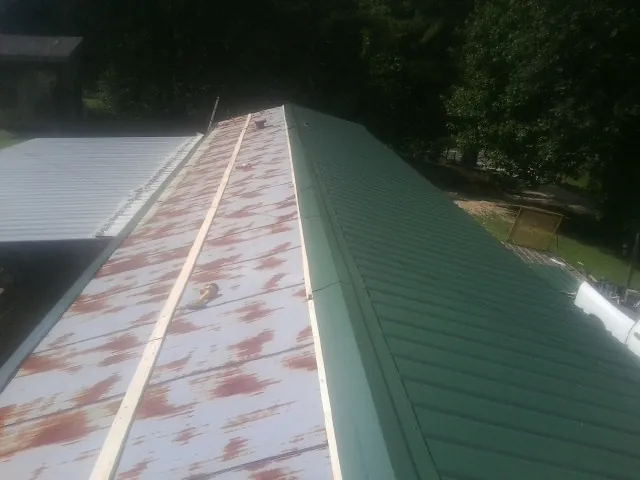 Old rusted panels beside newly installed green metal roofing — Wind Damage Roof Repair by Roofing Brothers in Redwood City
