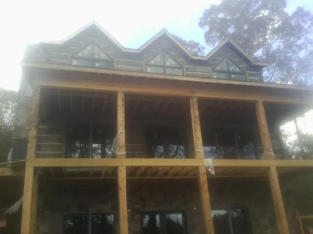 Dormers and porch framing on a large log home under construction — Roof Coating work by our crew in Redwood City
