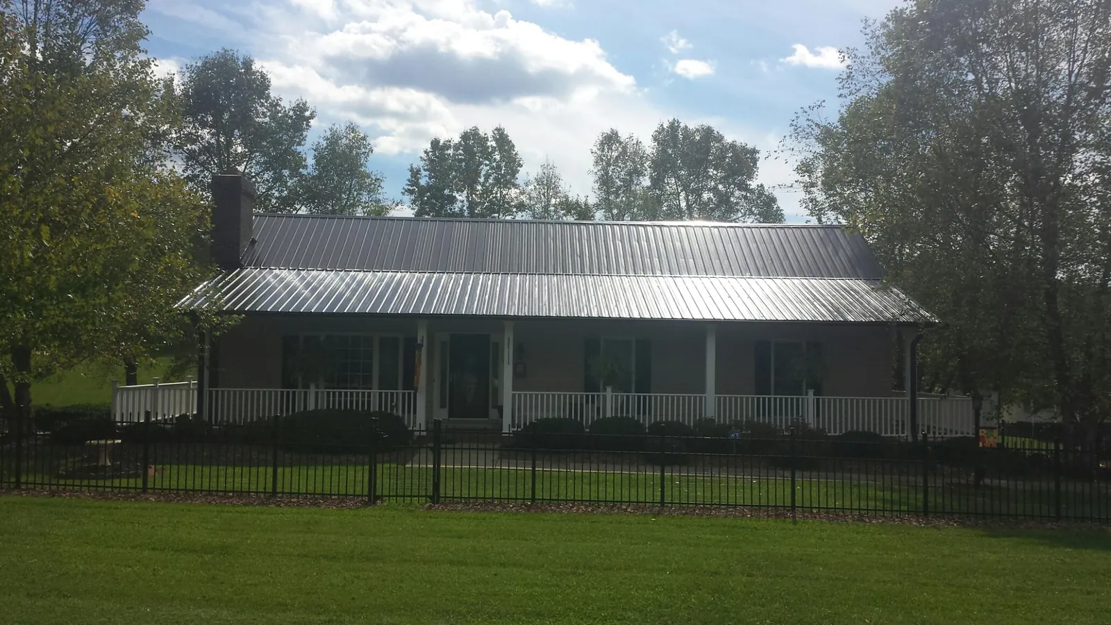 Gray metal roof on a brick ranch with a full width front porch — Gutter Guard Installation work by our crew in Redwood City