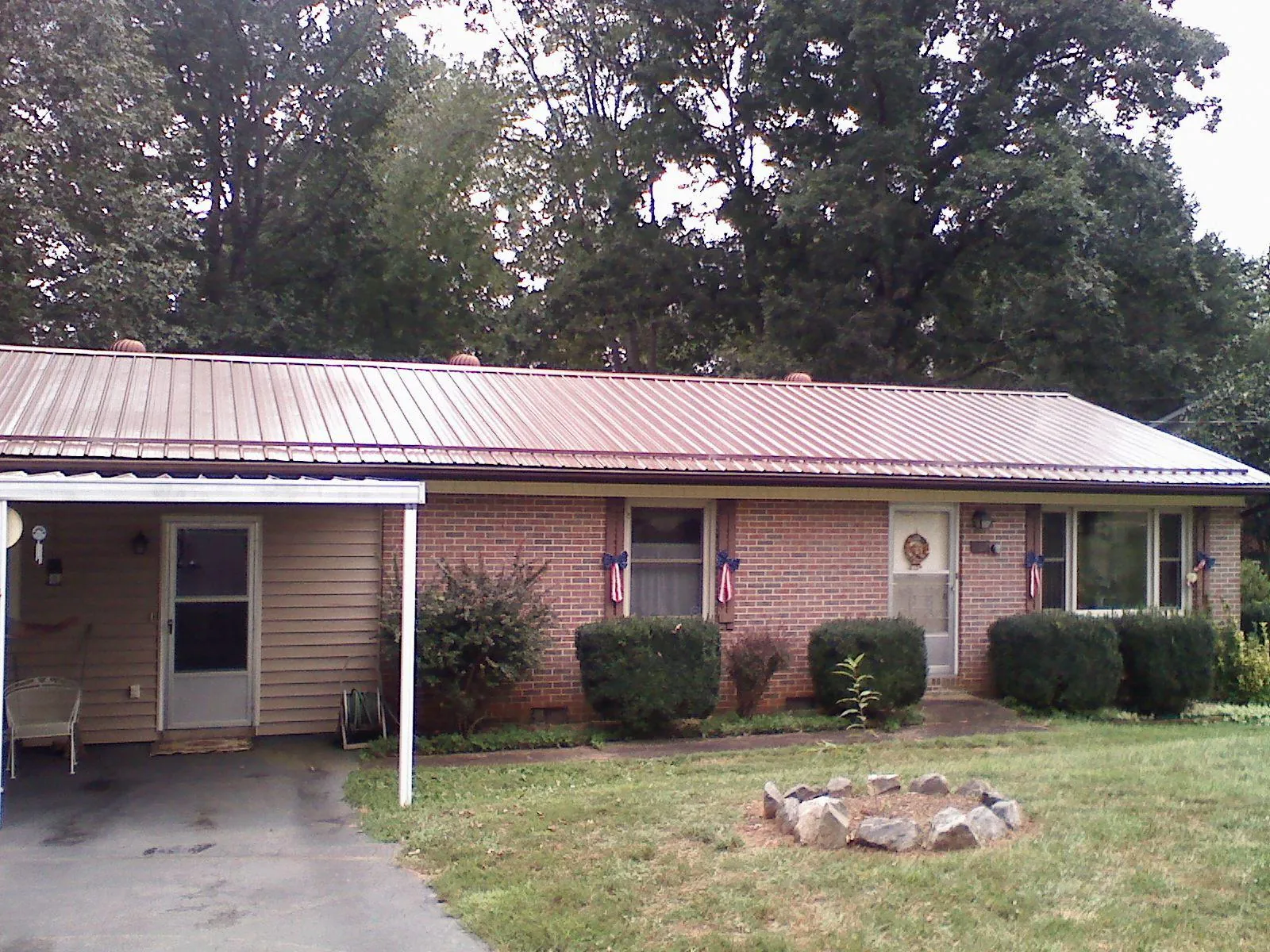 Bronze metal roof and carport on a brick ranch home — Roof Repair work by our crew in Redwood City