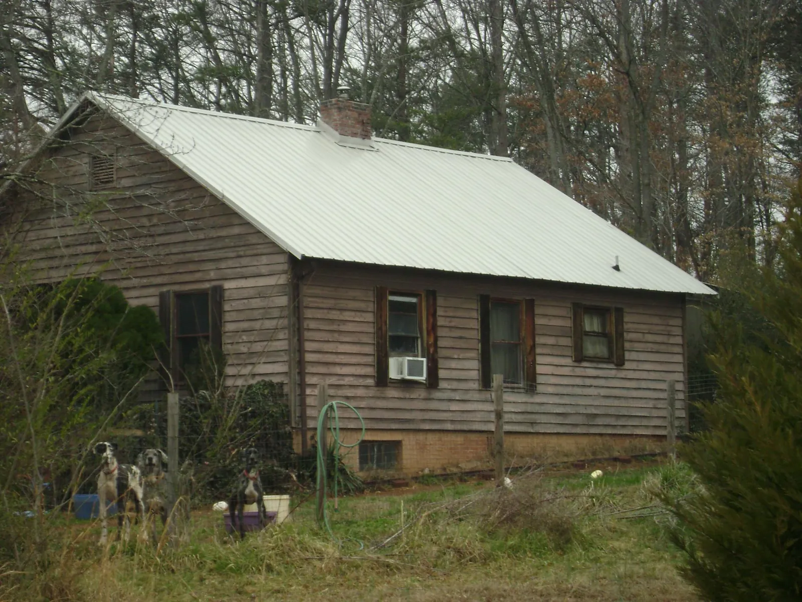 White metal roof on an old wood sided farmhouse, from a Metal Roof Installation job in Redwood City